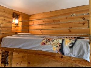 um quarto com uma cama e uma parede de madeira em Carpe Diem em Jumet