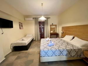 Habitación de hotel con 2 camas y TV en Mouse Island View Studios, en Perama