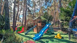 a playground with a slide in a yard with trees at Complex Parc Pini Moinesti in Moineşti