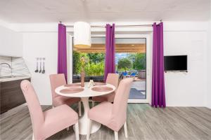 jadalnia z purpurowymi zasłonami oraz stołem i krzesłami w obiekcie Relax Derossi 2 w Crikvenicy