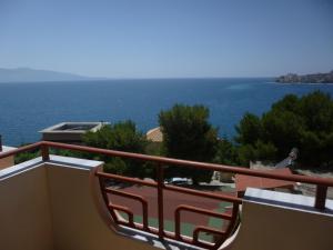a man standing on a balcony looking at the ocean at Hotel Chicago in Sarandë