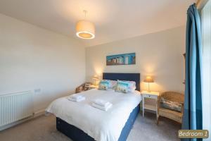 a bedroom with a bed with two towels on it at TenSea in North Berwick