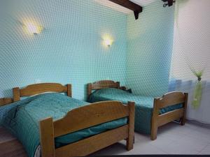 2 camas en un dormitorio con paredes azules en Domaine de Jouani - Pergola, en Villecomtal