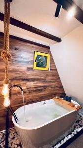 una grande vasca da bagno in una camera con pareti in legno di Porumbacu Garden a Porumbacu de Sus