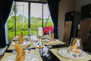 穆克莱克Do2poolvilla Khaoyai的一张餐桌,上面有黄色餐巾和玻璃杯