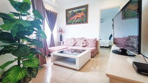 a living room with a couch and a plant at Queen Central Apartment Hotel in Ho Chi Minh City