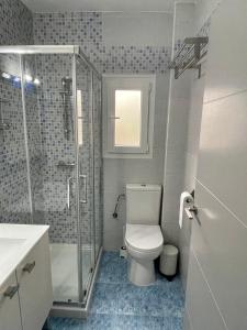 uma casa de banho com um WC e uma cabina de duche em vidro. em Doamvid Universidad em Ciudad Real