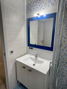 uma casa de banho com um lavatório branco e um espelho. em Doamvid Universidad em Ciudad Real