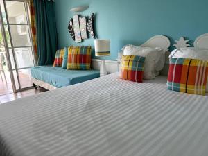 una camera con un grande letto bianco e un divano di Passion Caraïbe a Sainte-Luce