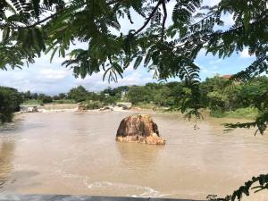a rock in the middle of a river at Dalis Waterfall Homestay in Lagi