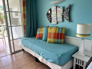 ein Sofa in einem Zimmer mit blauer Wand in der Unterkunft Passion Caraïbe in Sainte-Luce