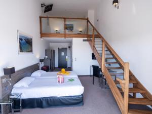 een slaapkamer met een bed en een trap bij Golden Tulip La Baule in La Baule