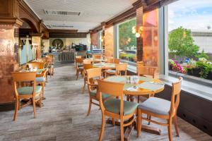 een restaurant met tafels en stoelen en een raam bij Danubius Hotel Regents Park in Londen