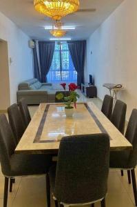 een eetkamer met een tafel met stoelen en een bank bij Haris Homestay 3 Bedroom and 2 Bathroom in Kota Bharu