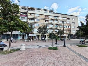 a large building with a courtyard in front of it at Red Square Apartment in Pirot