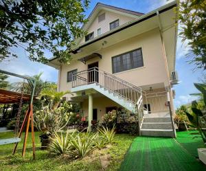 a house with a green lawn in front of it at Belle Montagne Holiday Apartments in Grand'Anse