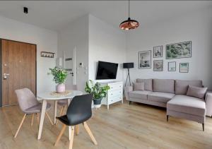 ein Wohnzimmer mit einem Sofa und einem Tisch in der Unterkunft SEN W GDAŃSKU - APARTAMENTY przy MOTŁAWIE - GDAŃSK STARE MIASTO in Danzig