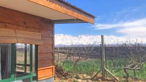 a building with a view of a field and mountains at El Atelier - Valle de Uco in La Consulta