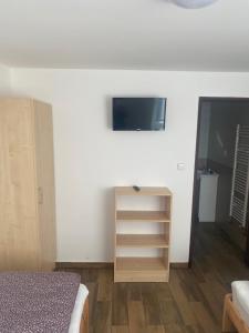1 dormitorio con 1 cama y TV en la pared en Penzion Norden, en Mariánské Radčice