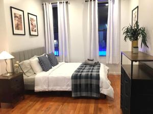 a bedroom with a bed and a dresser and windows at Cozy Studio Chinatown! Location! in New York