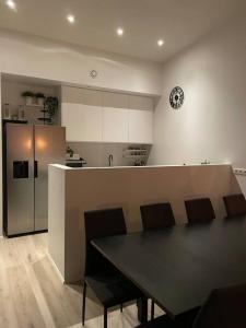een keuken met een tafel en stoelen en een koelkast bij A cozy home away from home in Hveragerði