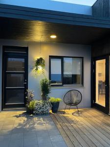 a bench sitting on a porch of a house at A cozy home away from home in Hveragerði