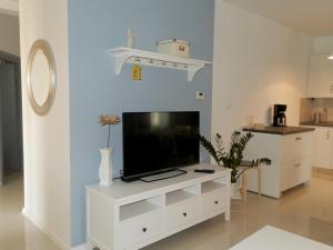 ein Wohnzimmer mit einem TV auf einem weißen Entertainment-Center in der Unterkunft Apartment Kiki Candy in Malinska