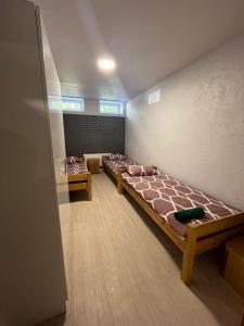 a room with three bunk beds in a room at Hostel Vytista in Raseiniai