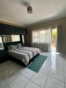 a bedroom with a bed and a large window at Beautiful Home in Houghton in Johannesburg