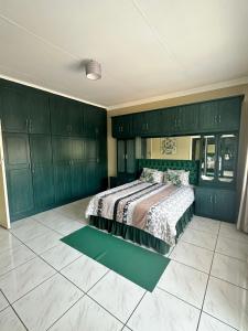 a bedroom with green cabinets and a bed in it at Beautiful Home in Houghton in Johannesburg