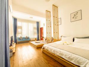 a bedroom with a large bed and a living room at Dali Ancient City Xinyu Xuan B&B - Erhai Gate Branch in Dali