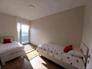 1 dormitorio con 2 camas y ventana en Bosphorus City 2+1 daire en Estambul