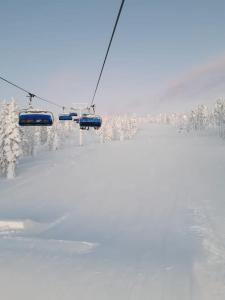 a ski lift in the snow with snow covered trees at Levi Holiday home Poroileville in Kittilä