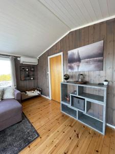 sala de estar con sofá y suelo de madera en Orretuen, en Austevoll