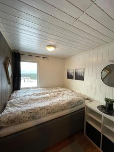 1 dormitorio con 1 cama grande y ventana en Orretuen, en Austevoll