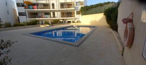 a swimming pool in front of a building at Apartment in the center of Tavira with swimming pool and garage in Tavira