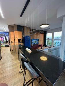 a kitchen with a black counter top and a living room at 8Flor Sokolska 30 Katowice in Katowice