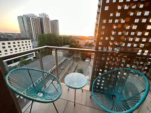 a balcony with two chairs and a view of a city at 8Flor Sokolska 30 Katowice in Katowice