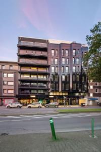 a building with cars parked in front of a street at Design-Apartment - Bochum Zentrum - 2 Balkons - 118m2 - Netflix in Bochum