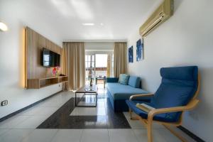 ein Wohnzimmer mit einem blauen Sofa und einem Tisch in der Unterkunft One bedroom with pool at 500m from Playa Chica, Puerto del Carmen in Puerto del Carmen
