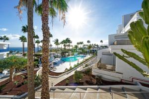 Blick auf den Pool des Resorts mit Palmen in der Unterkunft One bedroom with pool at 500m from Playa Chica, Puerto del Carmen in Puerto del Carmen