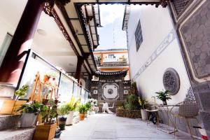 a hallway with potted plants in a building at Dali Ancient City Xinyu Xuan B&B - Erhai Gate Branch in Dali