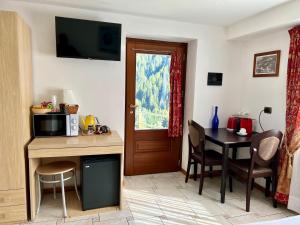 a room with a kitchen and a table with a microwave at Affittacamere Buenavista in Champoluc