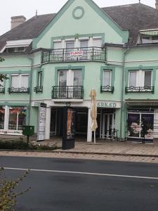 a green building with an umbrella in front of it at Kaktusz City in Hévíz