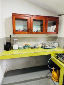 uma cozinha com um balcão amarelo com armários em Arcadia Resort em Hikkaduwa