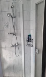 eine Dusche im Bad mit einem Telefon auf einem Regal in der Unterkunft Résidence Fotoulaise in Lüneburg