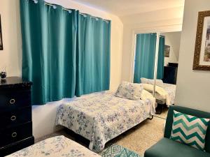 a bedroom with two beds and blue curtains at Leah's Homestay in Hoquiam in Hoquiam