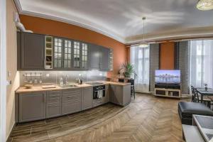 a kitchen with orange walls and stainless steel appliances at Your Worry Free Apartment Close To Parliament in Budapest