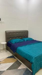 1 cama con edredón azul en un dormitorio en Kaklah Cherang Homestay en Kota Bharu