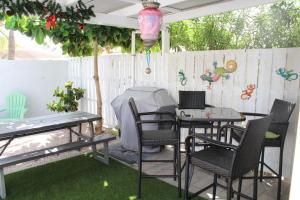patio ze stołem, krzesłami i ogrodzeniem w obiekcie Dancing Iguanas w mieście Oranjestad